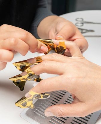 Manicurist is preparing nails for manicure in beauty salon. Young woman getting a manicure. Beautiful hands and nails. Macro photo. Nail Care.